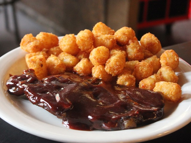 Pork steak can be served with fries or tots.