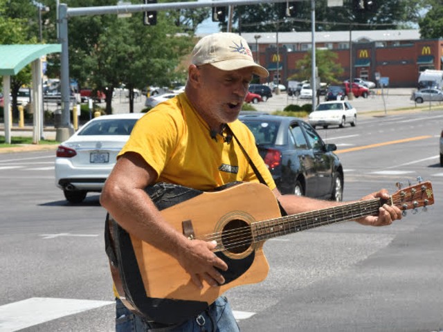 Roger 'Guitar Man' Ulrich playing a backup guitar after his was stolen on Monday.