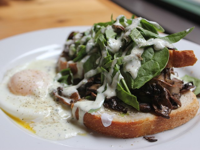 The "Artisan Toast" is topped with avocado, mushrooms and spinach, with an egg on the side.