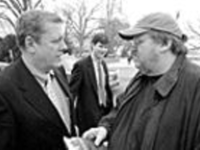 Michael Moore (right) talks with Congressman John 
    Tanner on Capitol Hill. Moore spent the day 
    approaching pro-war members of Congress to recruit 
    their children to fight in Iraq.