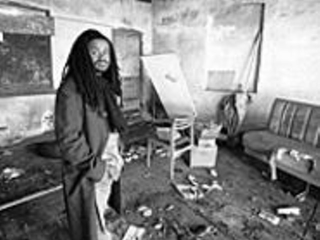 Reverend Osagyefo Uhuru Sekou stands inside a garage around the corner from where he lived as a kid