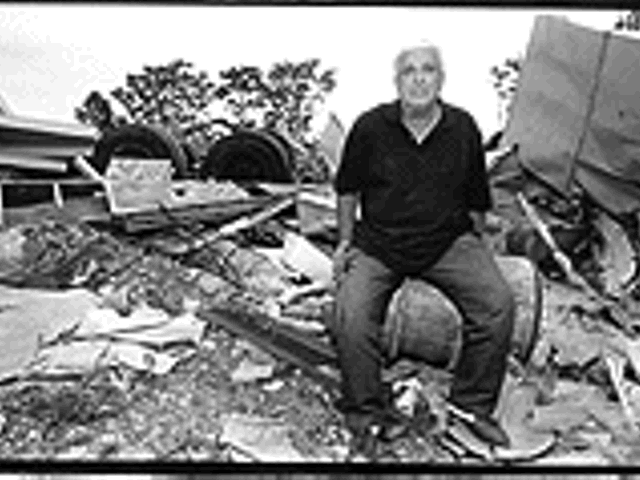 Marvin Andrew, co-owner of A-1 Iron and Metal, rests uneasily on the rubble left behind by a company headed by former state Rep. Tony Ribaudo.