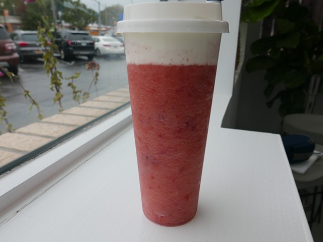 The layer of cream cheese sits in stark contrast to the strawberry slush.