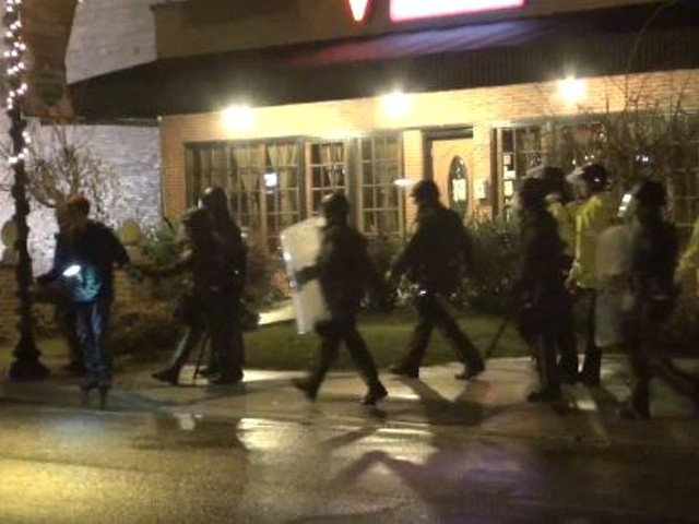 Police arrest Trey Yingst, on the left with a flash hanging from his neck, on November 22 in Ferguson.