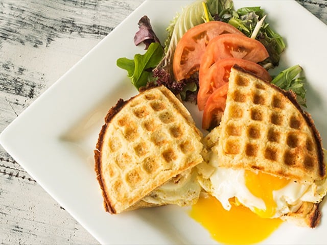 Melt's "Traitor Tot" sandwich: biscuit-batter waffle with hash browns cooked into the batter, layered with Canadian bacon, eggs, Swiss cheese and hollandaise. | Photos by Mabel Suen