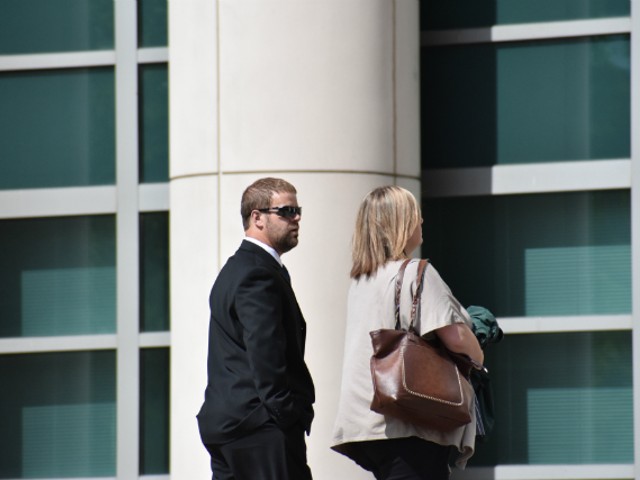 Ex-Mississippi County Sheriff Cory Hutcheson walks into federal court with his wife, Brittney.