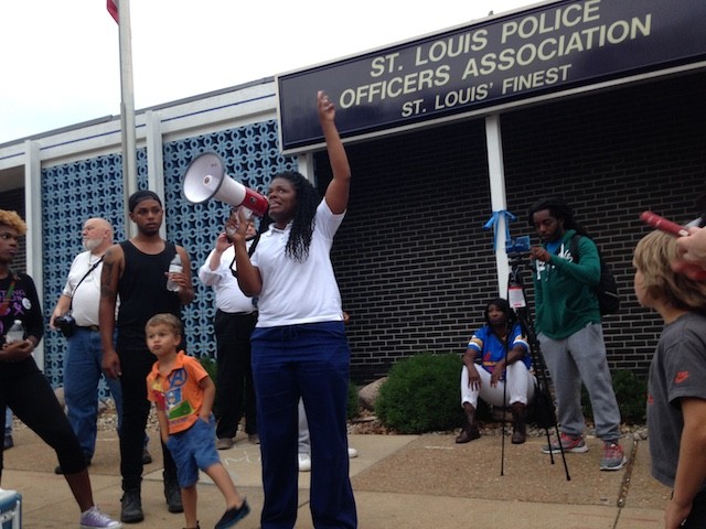 Cori Bush leads protesters in a chant in front of the St. Louis Police Officers Association.