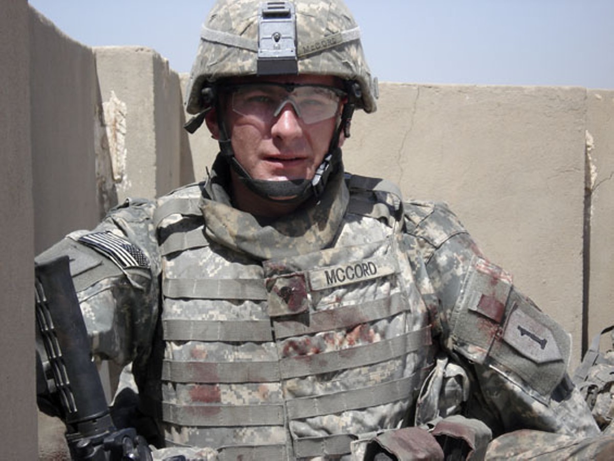 Ethan McCord on a rooftop in Baghdad on July 12, 2007, shortly after he rescued two wounded children from a van that was fired upon by U.S. Army helicopters. Blood from the children can be seen on his uniform.