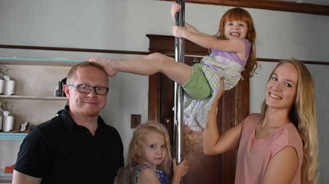 Lindsey Teall and Jake Night with five-year-old Laura and three-year-old Roslyn and the family's living-room pole.