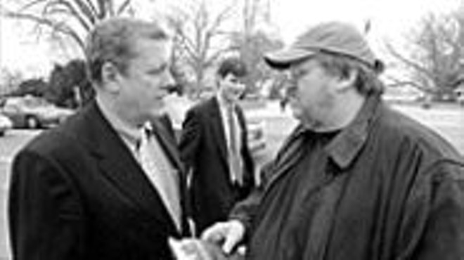 Michael Moore (right) talks with Congressman John 
    Tanner on Capitol Hill. Moore spent the day 
    approaching pro-war members of Congress to recruit 
    their children to fight in Iraq.