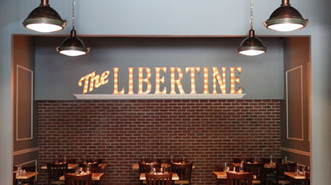 A large illuminated sign anchors the dining room at The Libertine. | Evan C. Jones