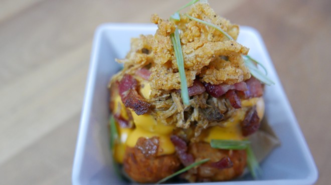 "The Loaded Pucks" are tater tots covered in beer cheese sauce, pulled pork, bacon, and fried onions.