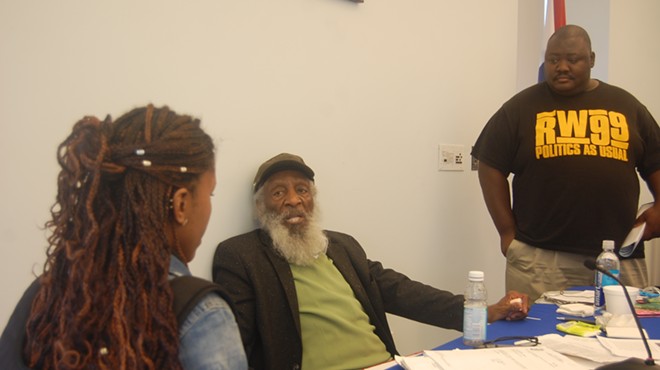 Scholars Brittany R. Mosley and Jeremy Shaw gathered around Dick Gregory to have autographs signed and ask questions.