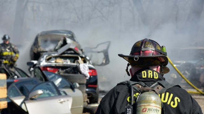 St. Louis firefighters work to put out cars in a salvage yard near Manchester Avenue.