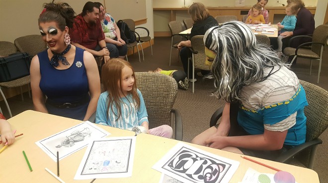 Five-year-old Olivia McArthy chats with local drag performers Celeste Covington (left) and Princess Hoodlum at Webster University.