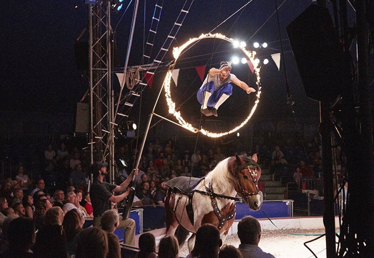 A member of La Tarumba leaps through a ring of fire. The Peruvian troupe fuses circus with theater, music and equestrian arts.