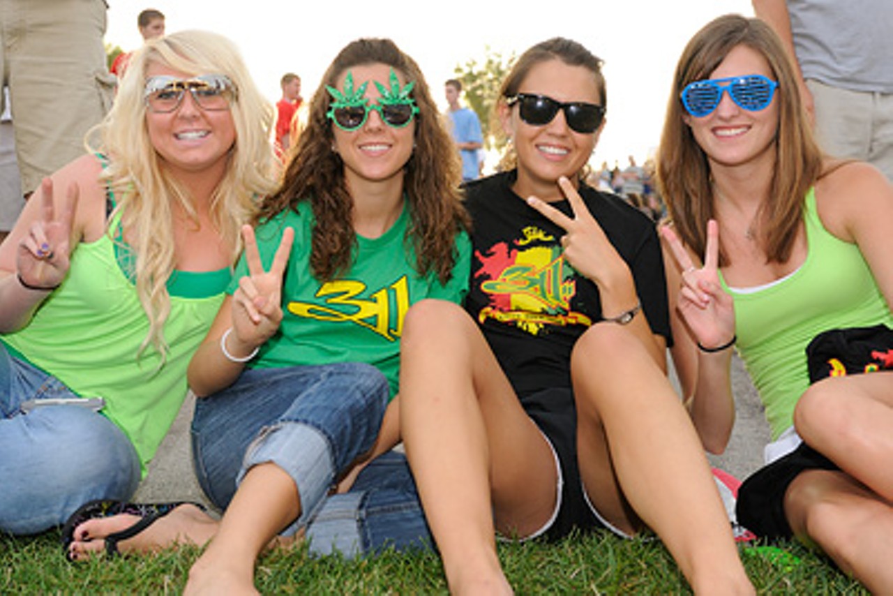 Four 311 fans throw up peace signs while rocking sunglasses and 311 shirts at the Verizon Wireless Amphitheater.