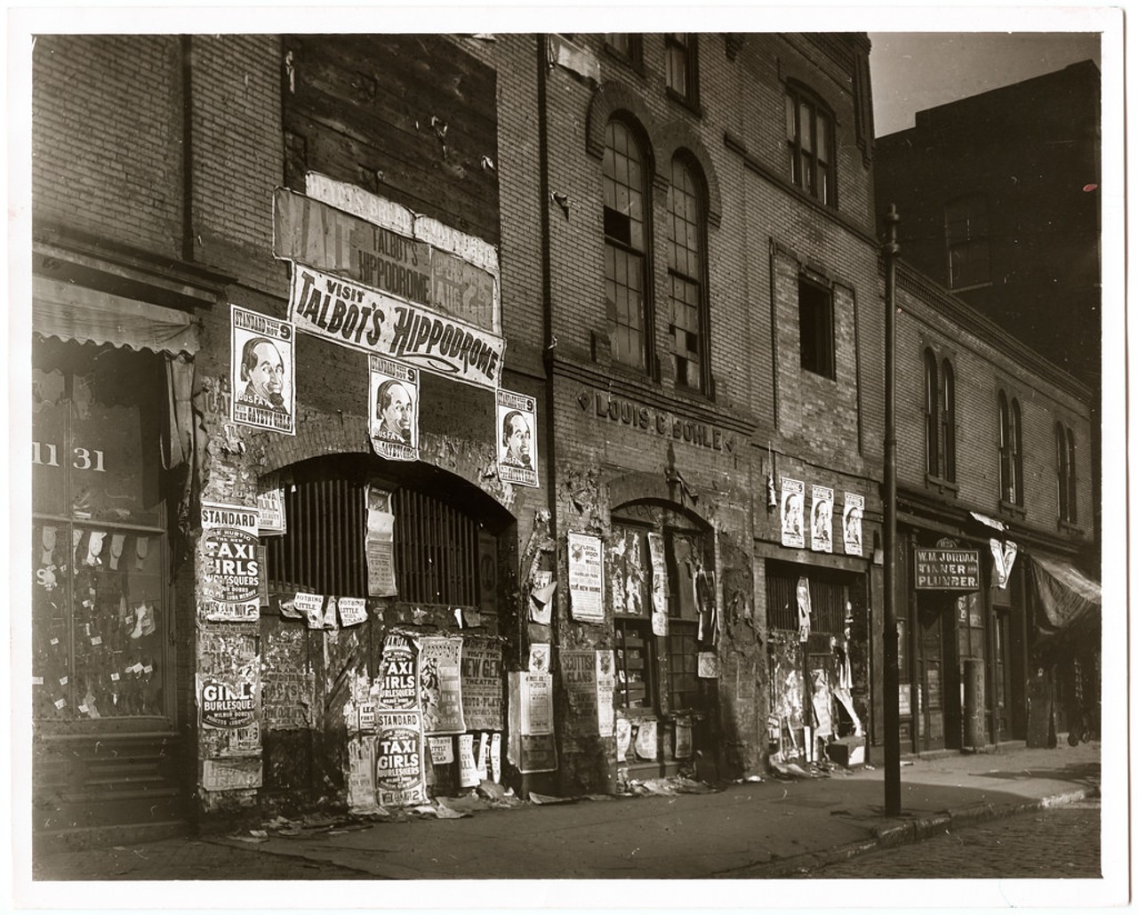 Posters covering a wall of the Louis Bohle Undertaking and Livery building at 1125&#150;9 Market Street advertising vaudeville shows at the Talbot's Hippodrome. Photograph, ca. 1907.