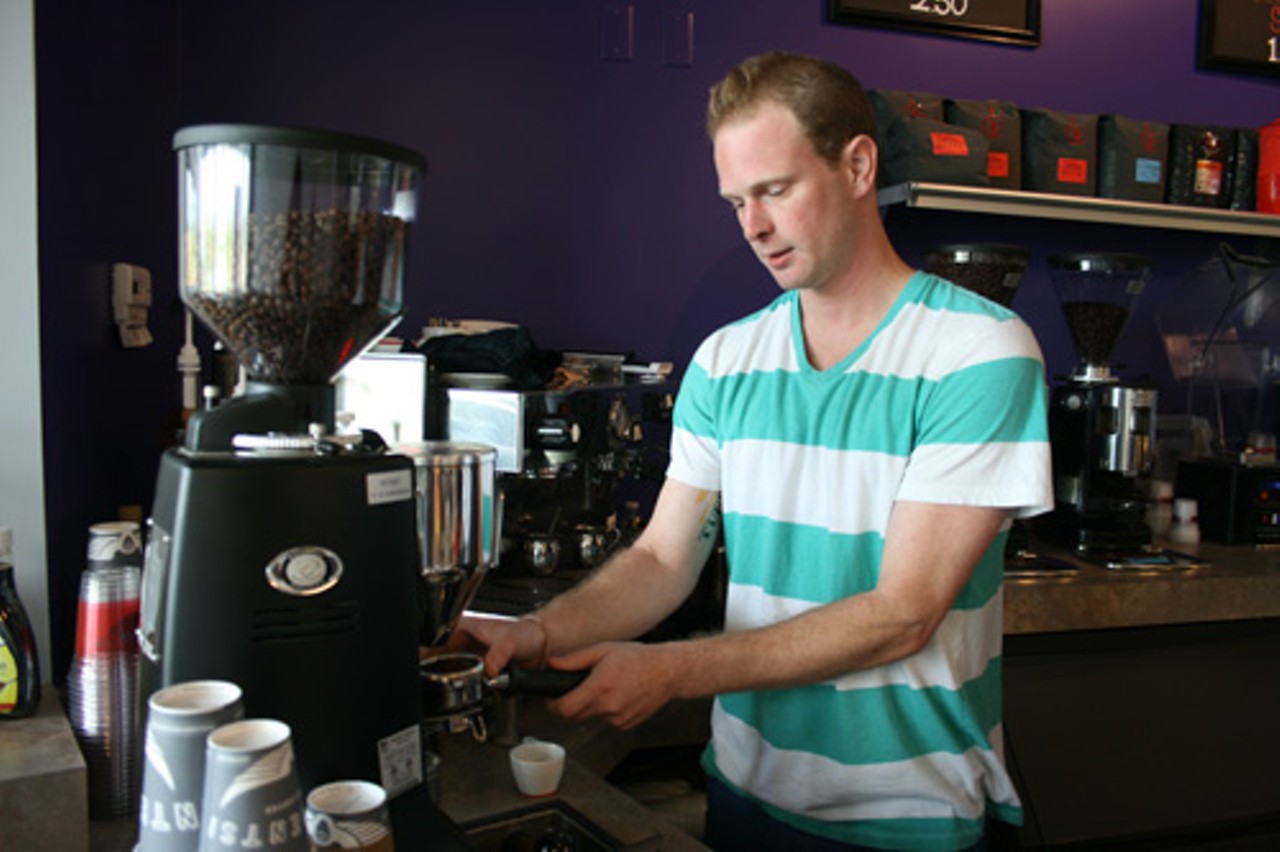 Shop manager Zach Althaus grinds espresso beans.