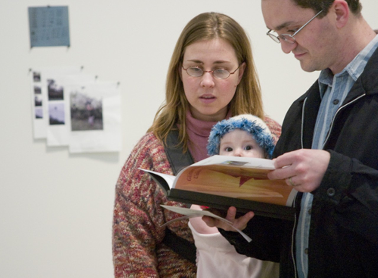 Bryan Rickert and his wife Rita from Belleville, Ill., read Glitterous' mission as their 6-month-old daughter, Leontine, looks on.