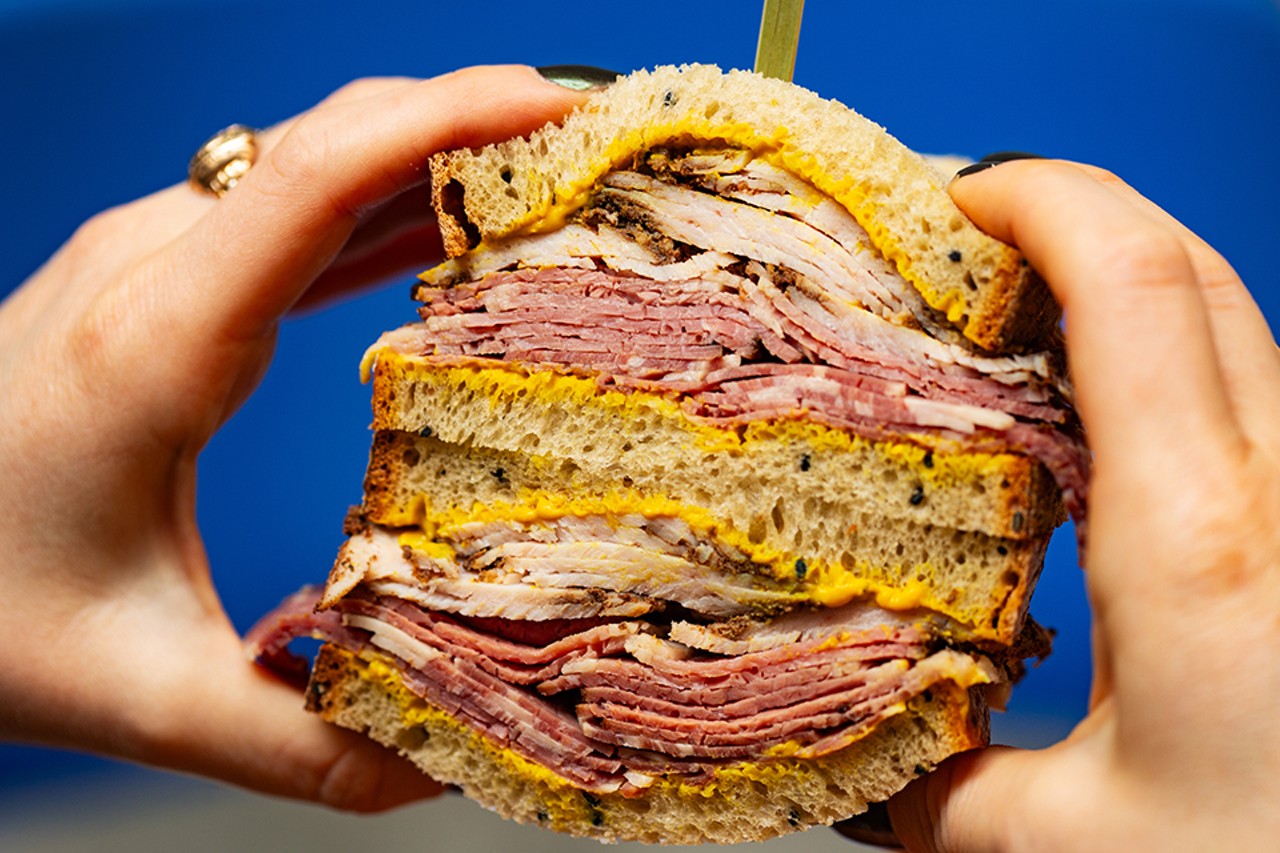 Combo sandwich of smoked turkey and pastrami on rye with mustard.
