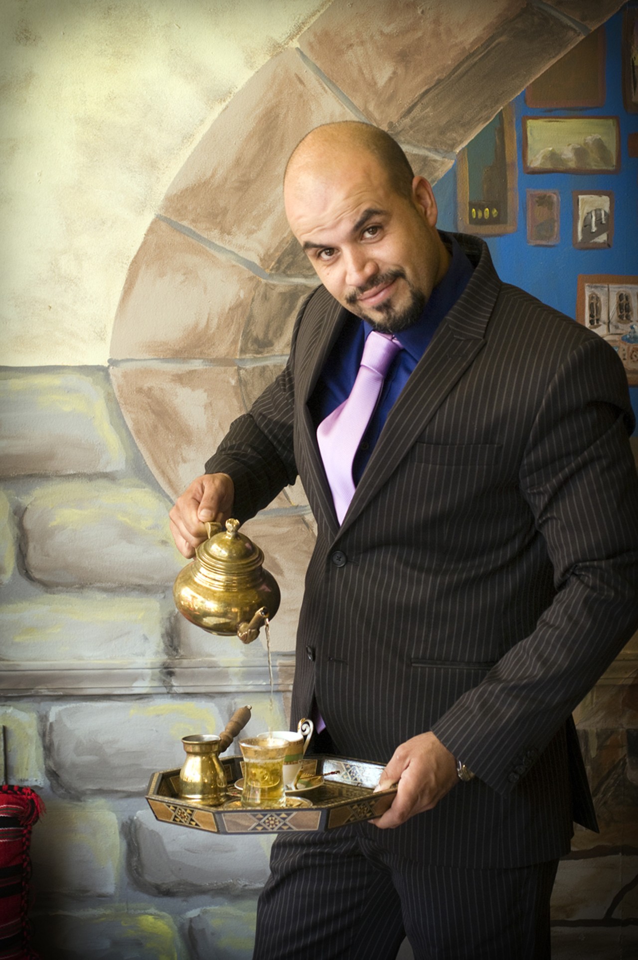 Owner Aboud Alhamid pouring a cup of Mint Tea.