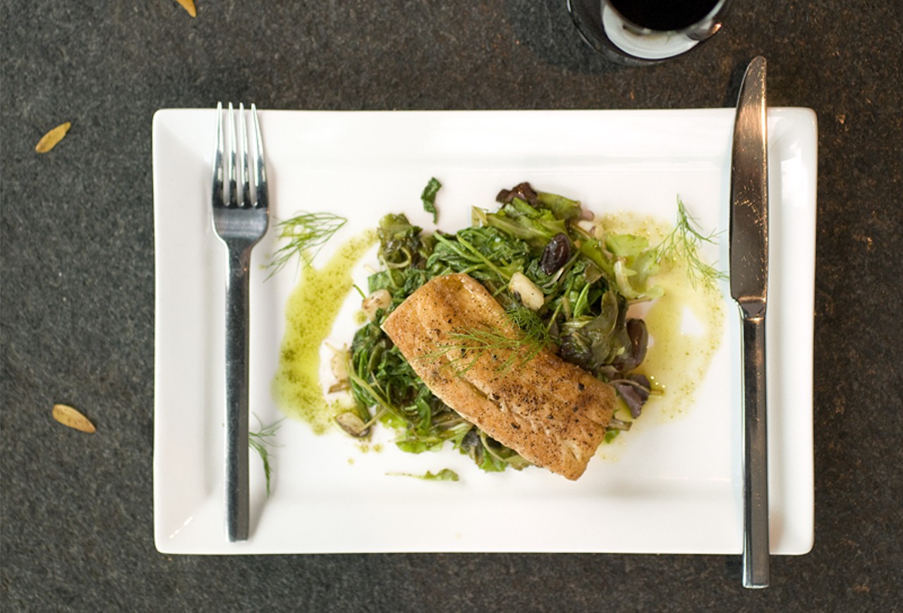 Lake Superior Walleye is served on wilted greens and arugula with fennel olives, cucumbers, tomatoes and extra virgin olive oil with basil.