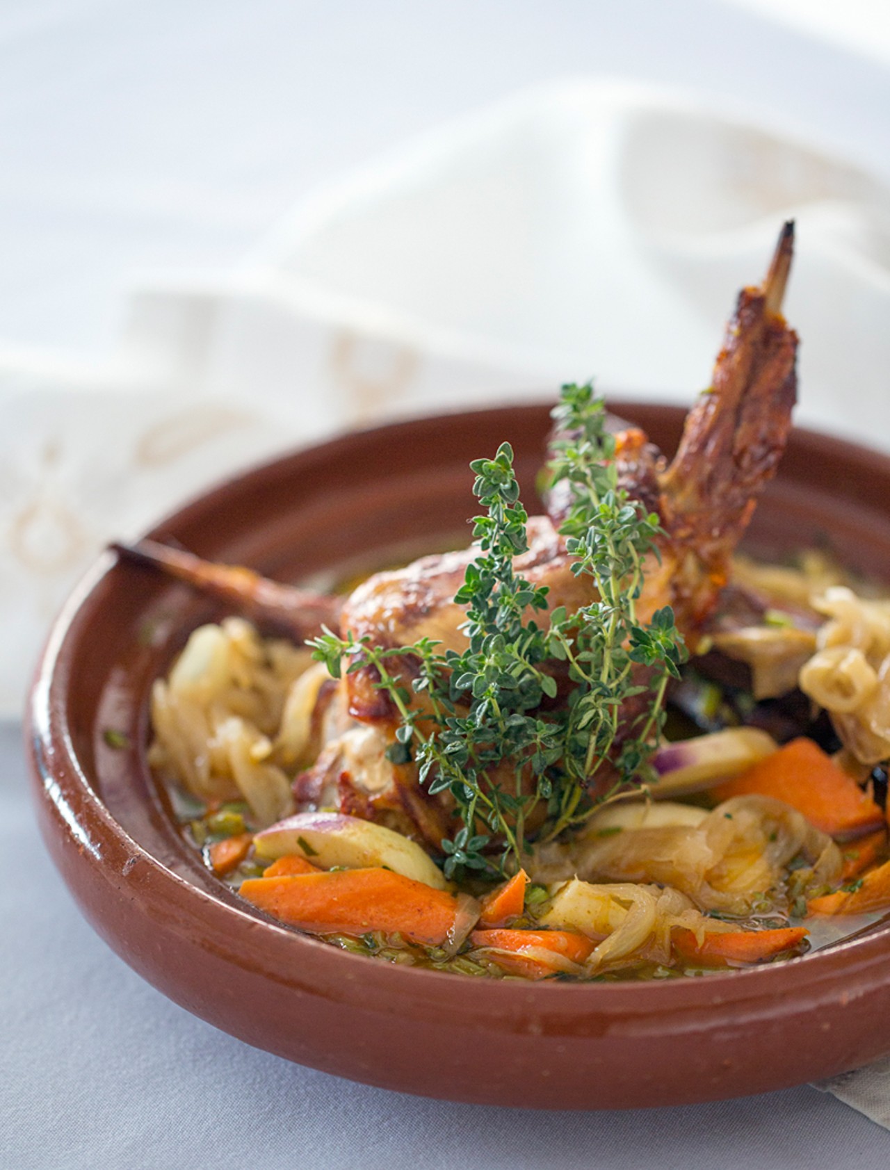 Rabbit tajine is slowly braised with onions, carrots, turnips and potatoes and is served in a rich herb broth.