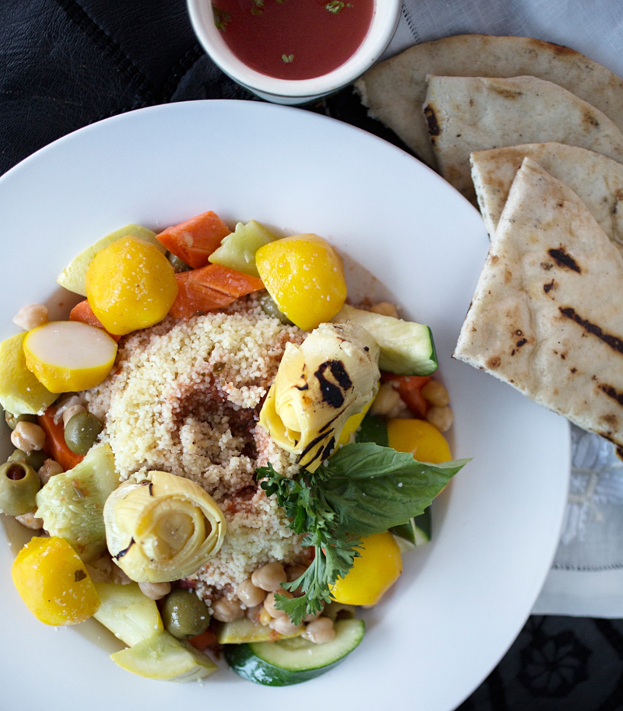 The vegetarian couscous is prepared with large cuts of seven vegetables and garbanzo beans atop a bed of couscous. A warm seasoned broth is served on the side.