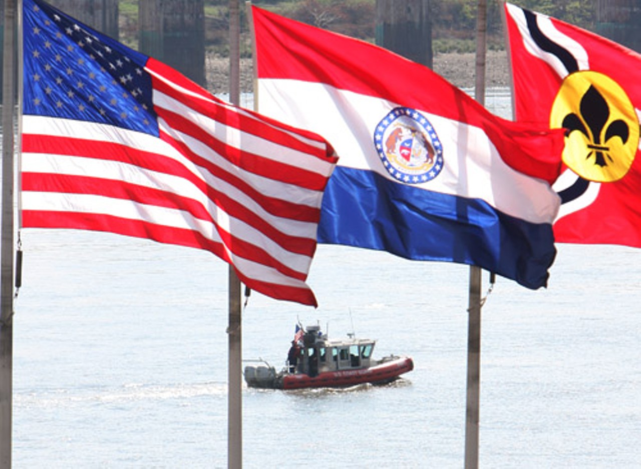 The U.S. Coast Guard hangs out on the Mississippi River below the flags on the riverfront.