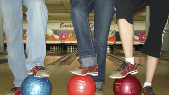 Three people step on bowling balls on a bowling lane at Epiphany Bowling Lanes