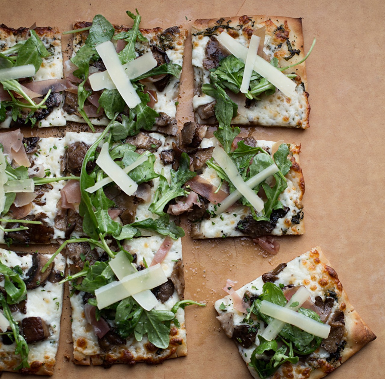 Its "Farmhouse White" pizza is topped with roasted garlic-herb oil, mozzarella, and wild mushrooms, then finished with prosciutto, shaved parmesan and arugula