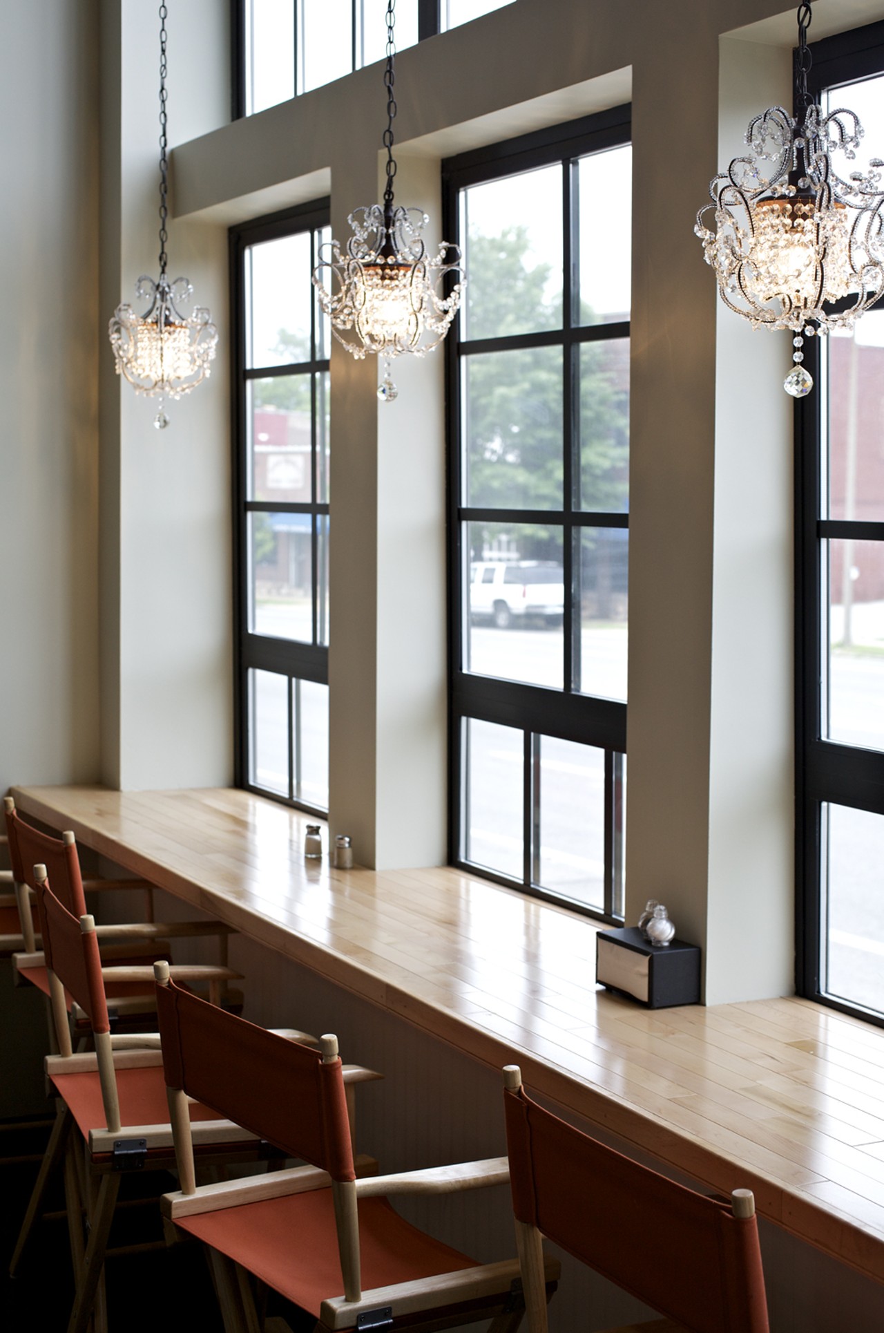 Sweet chandeliers line the bar-height seating along the wall of windows at the front of the bakery.