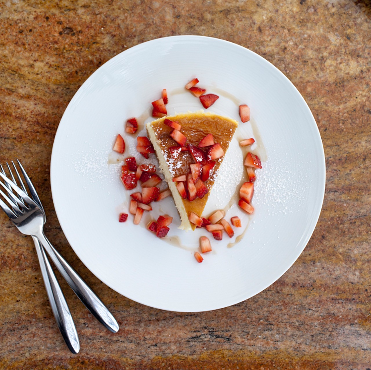Mascarpone cheesecake with a biscotti crust and fresh balsamic strawberries.