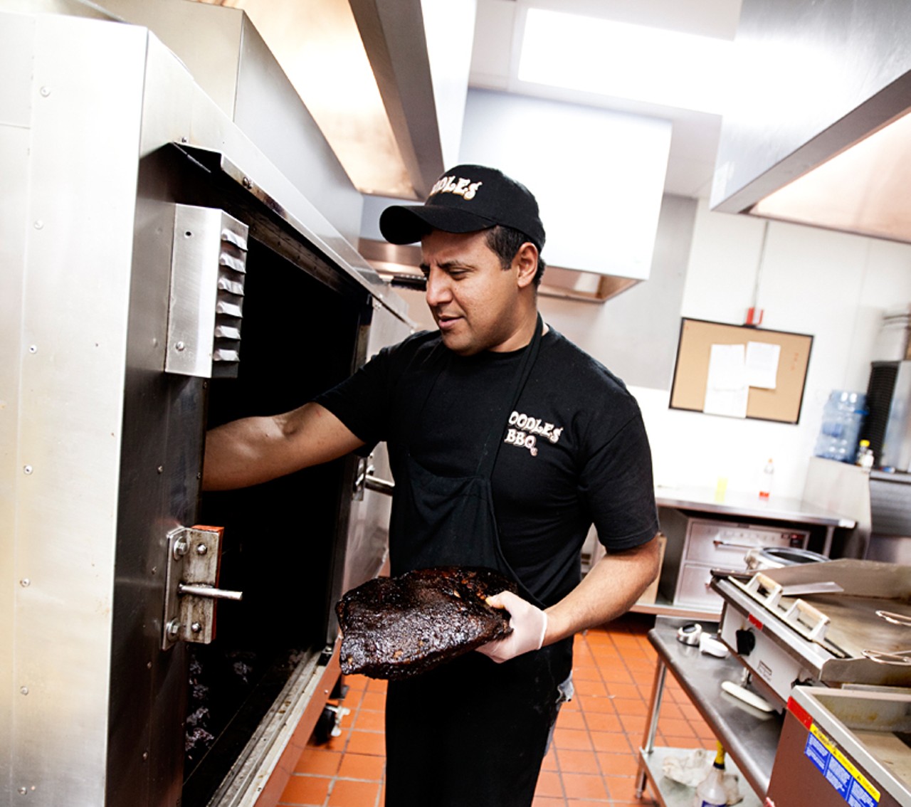 Dennis Machado (part-owner of Boodle's) getting a brisket out of the smoker.