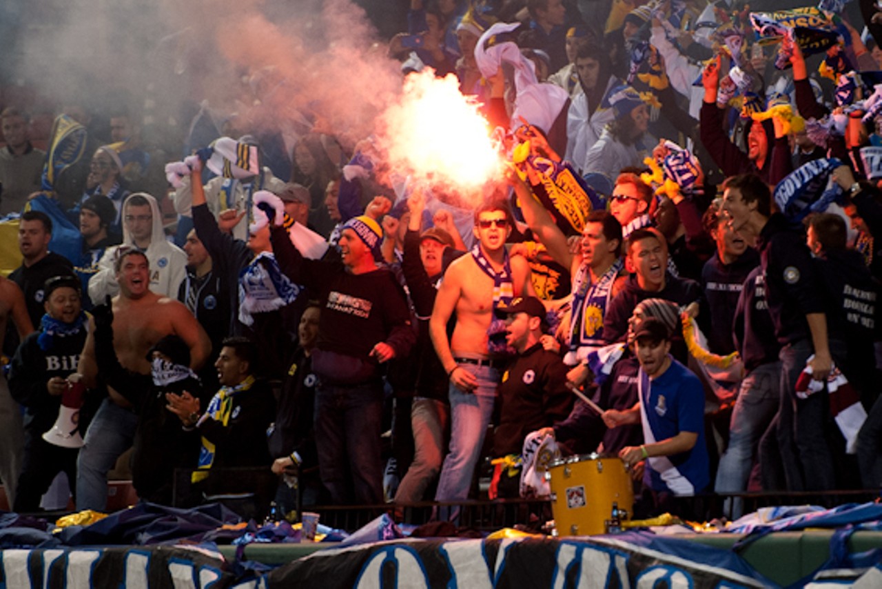 Fans light a flare in the stands.