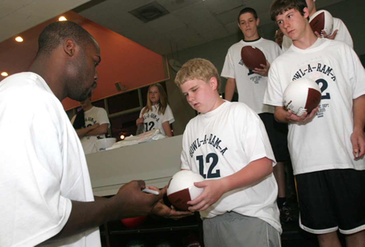 Cameron Hollander gets a football signed by the event co-chairman and Rams linebacker, Will Witherspoon.