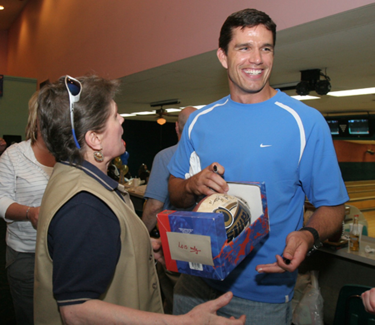 Rams quarterback Trent Green has a laugh with longtime fan, Lois Linton. She has not missed a game since the Rams moved to St. Louis, and here she&rsquo;s describing where her seats are in the dome.