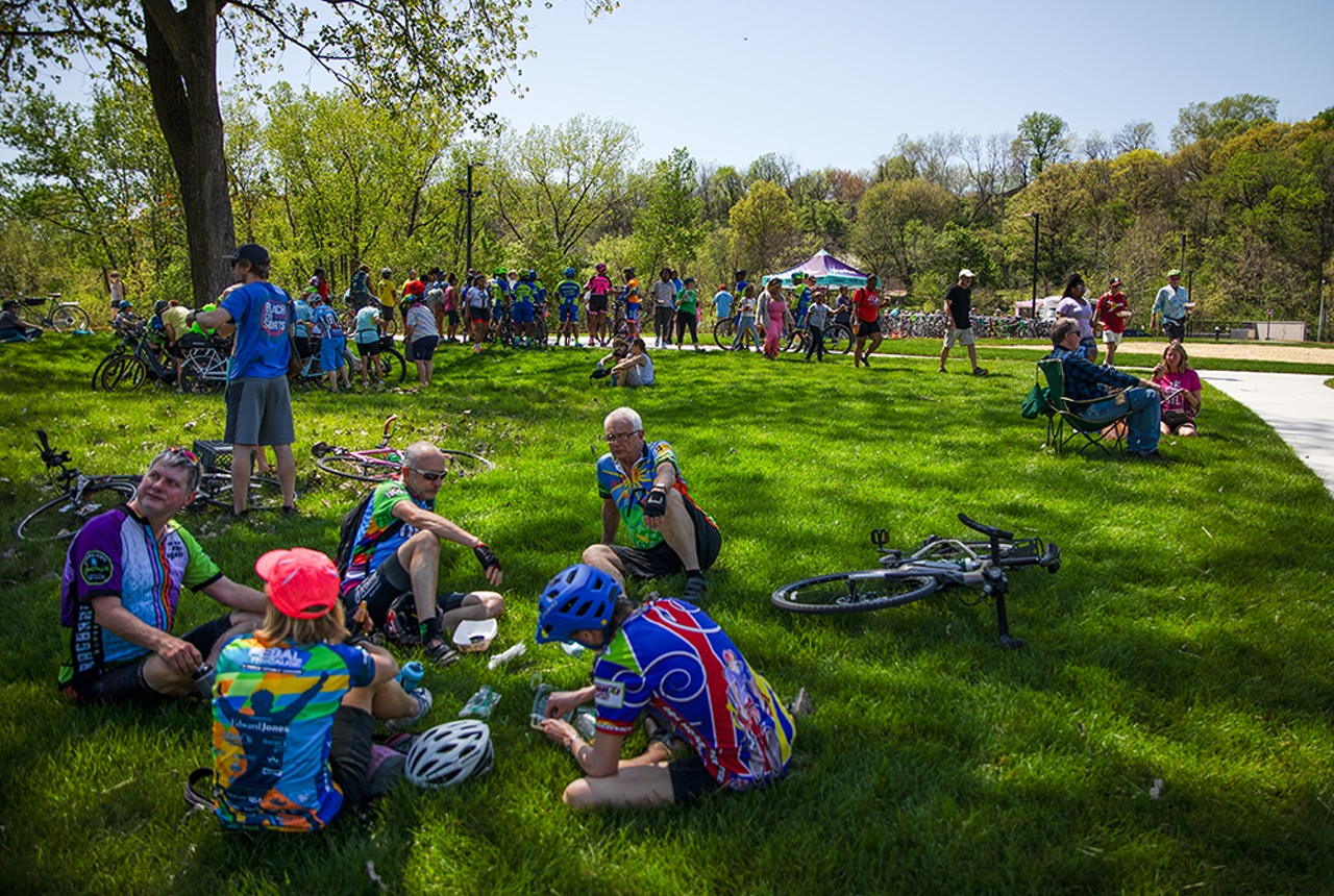 Cyclists relax in the grass after a group ride to kick off the opening of the Chain of Rocks Park.