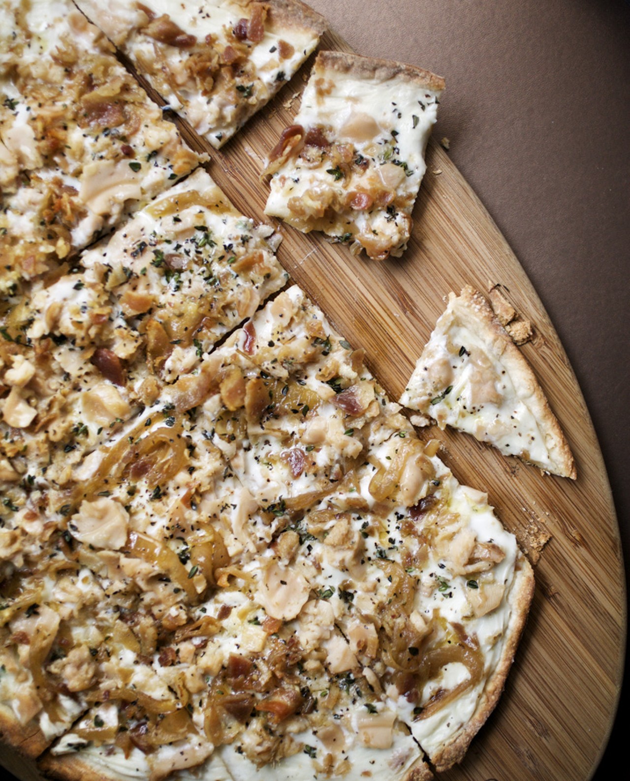 White Clam Pizza is made with fresh clams, thyme, pancetta, garlic, caramelized onions and white sauce.