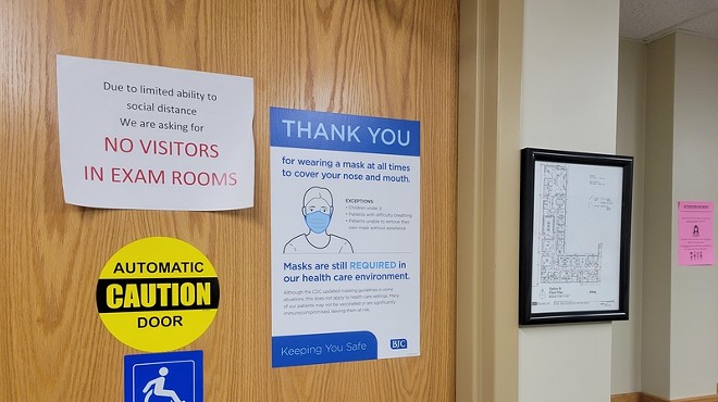 Signs on the door of a Barnes-Jewish Hospital clinic show various pandemic-related restrictions. The region's hospitals are seeing unprecedented numbers of pediatric COVID cases.