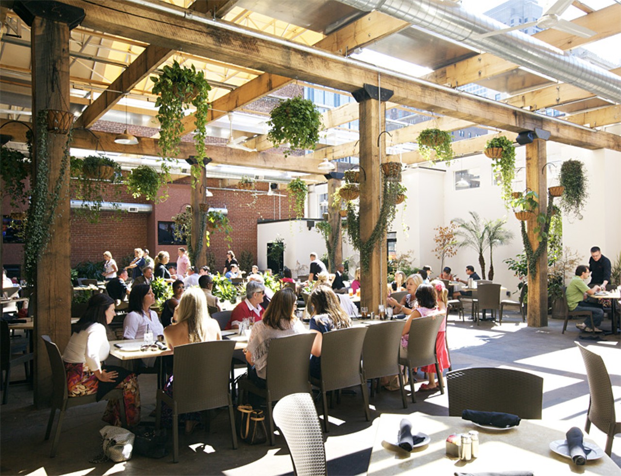 The rear dining room features a retractable roof and lush greenery.