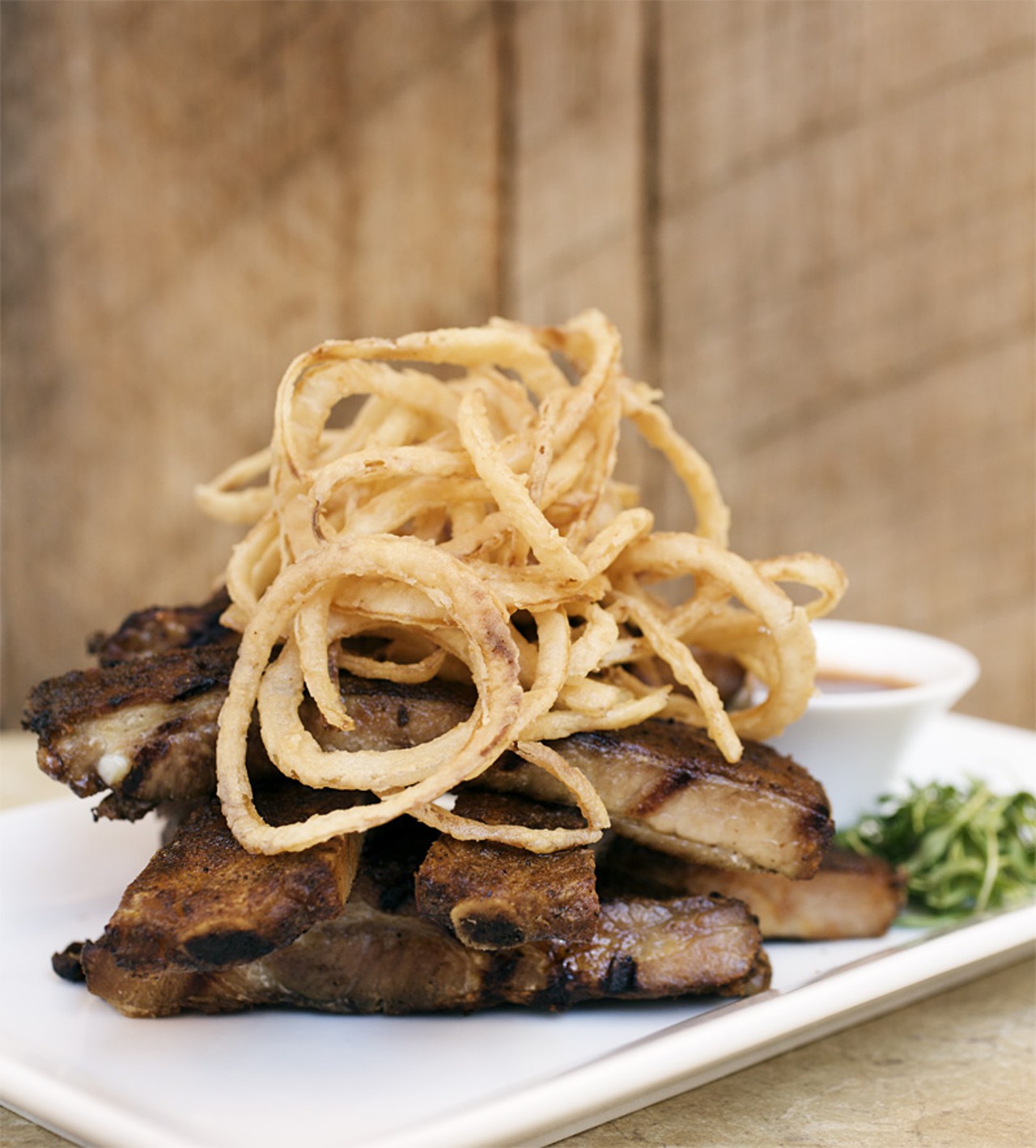 This impressively sized appetizer is the Smoked Spare Ribs served with a tangy bbq sauce and tobacco onions.