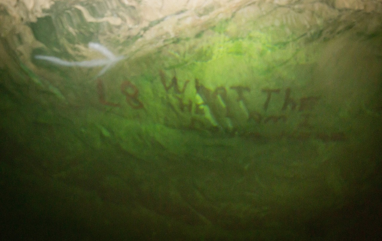 A miner spraypainted "What the hell am I doing down here" on the mine's wall. His grafitti is now under water.