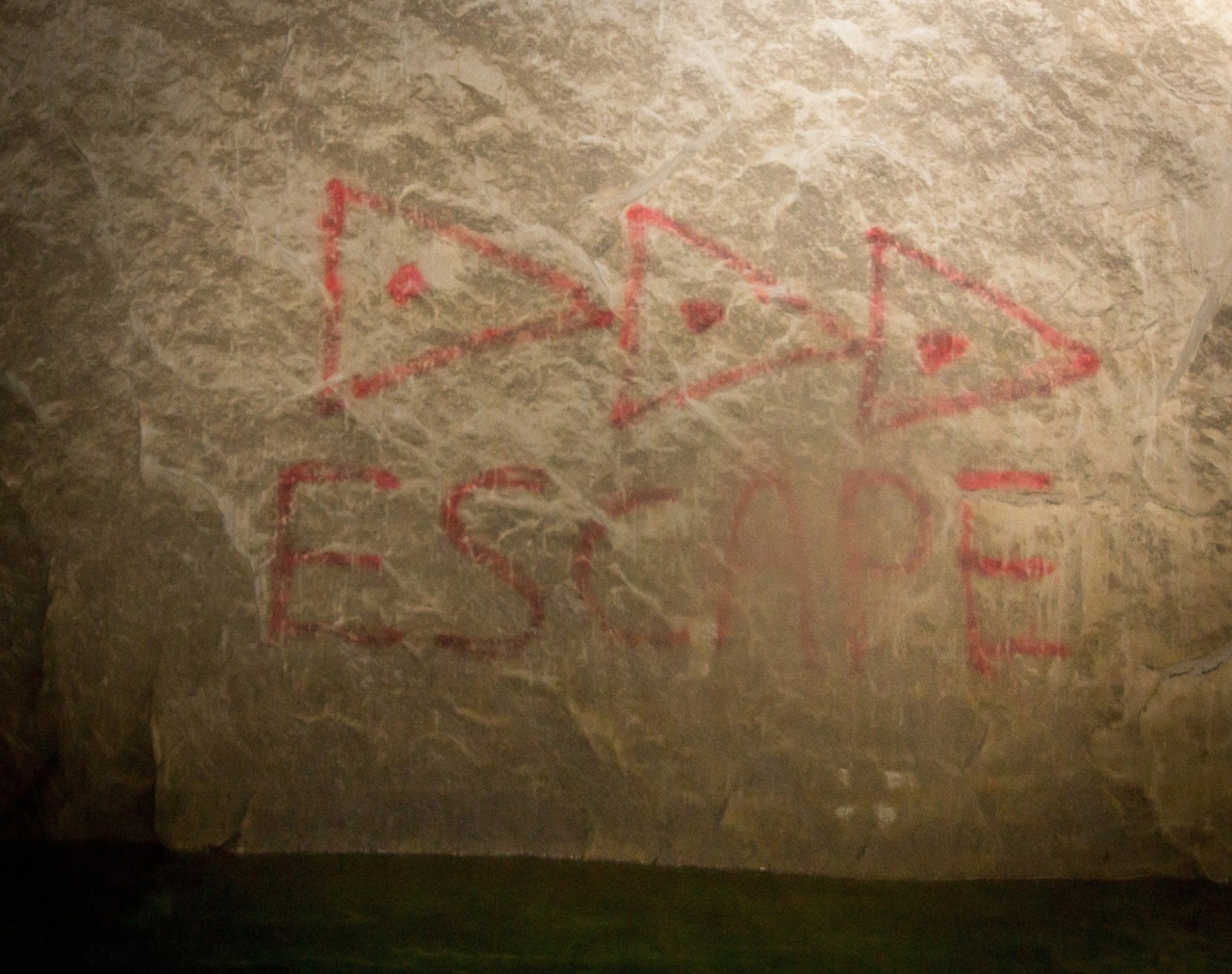 The miners marked the escape route to be used in case of an emergency with three triangles pointing toward an exit.