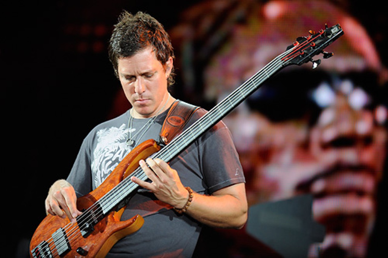 Bassist Stefan Lessard, with an image of Violinist Boyd Tinsley behind him.