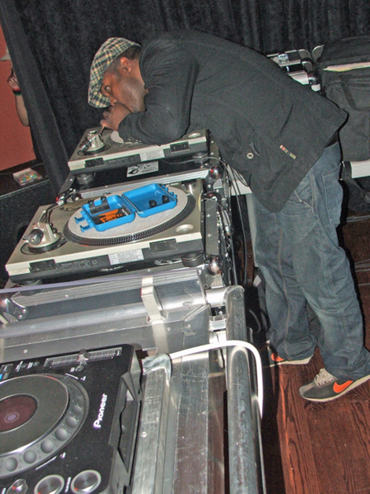 St. Louis' DJ Needles preps his turntables about 9:59 p.m. Thursday. A line waits outside for the doors to open.