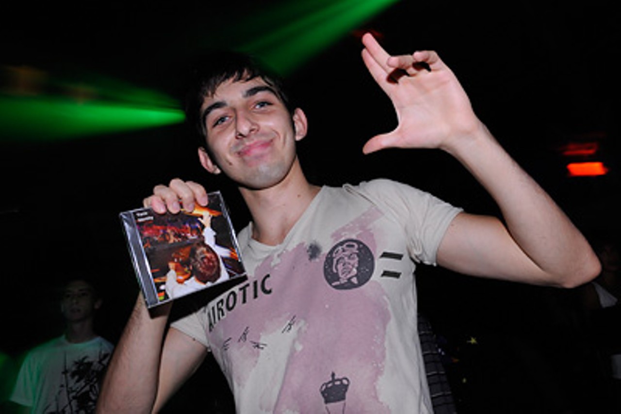 An enthusiastic fan holding up a copy of DJ Yanix's CD.