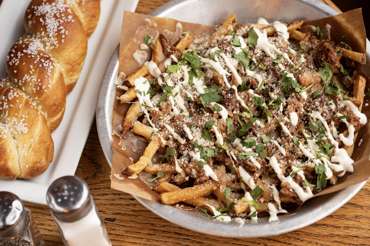 Cuban street fries with house-cut fries, mojo-braised pork, cheese blend, lime crema and cilantro.