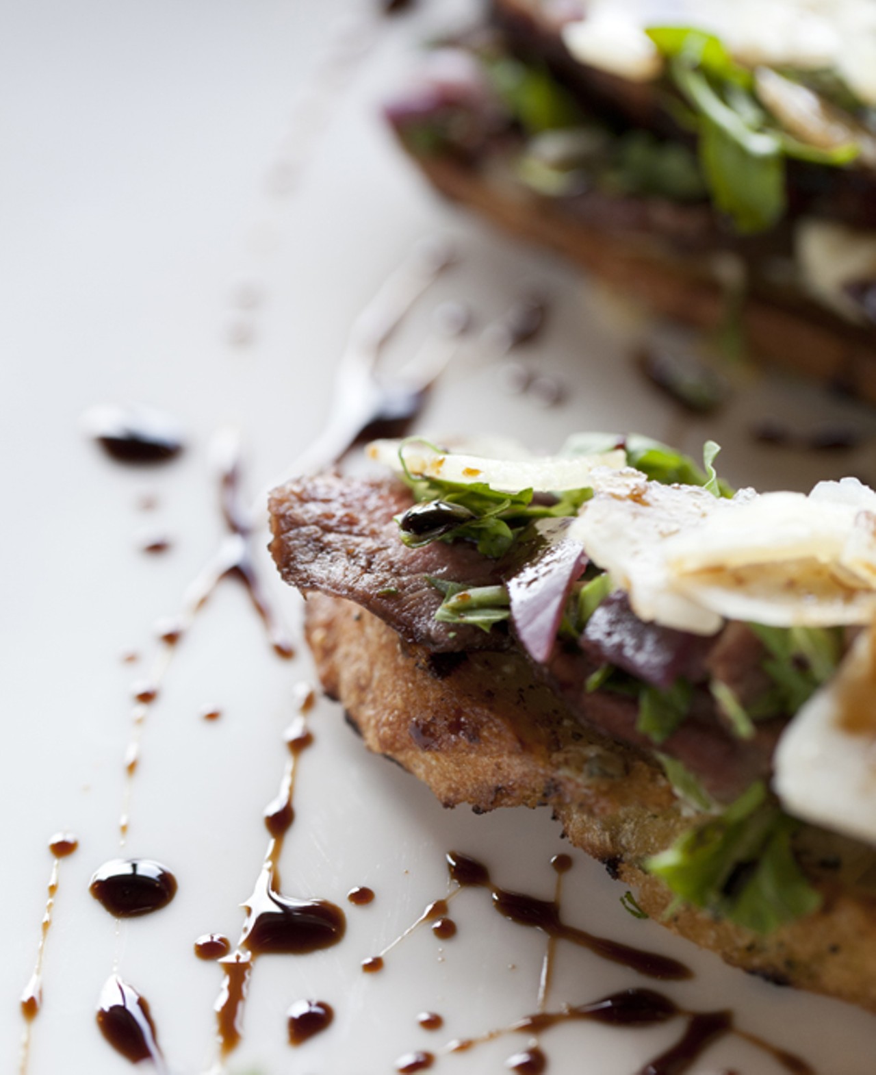 Steak Bruschetta - rosemary flank steak, blue cheese, arugula, chianti braised shallots, grilled baguette, shaved parmesan and balsamic reduction.